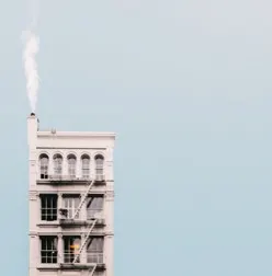 Immeuble blanc à escalier de secours, fumée de cheminée